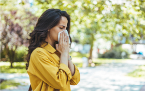 Frau schneutzt sich in ein Taschentuch